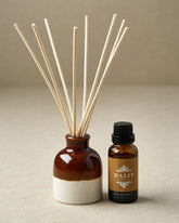 Diffuser bottle with reeds and smaller bottle labeled &