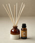 Diffuser bottle with reeds and smaller bottle labeled &