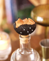 Decorative bottle stopper shaped like a hedgehog on a blurred background