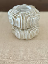 Stack of ribbed ceramic bowls on a beige surface