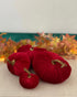 Red velvet pumpkins with gold stems on a neutral background