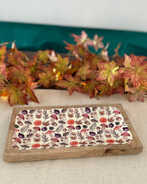 Decorative tray with leaf pattern on a table with autumn leaves in the background