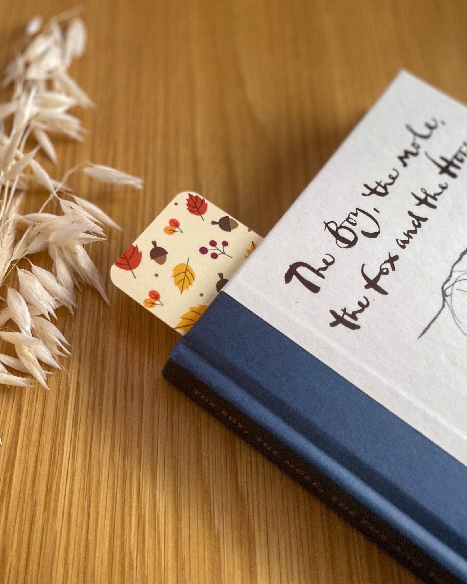 Autumn-themed waterproof bookmark featuring vibrant leaves in autumn colours, made from recycled tear-proof card stock with a velvet lamination. Perfect for book lovers.