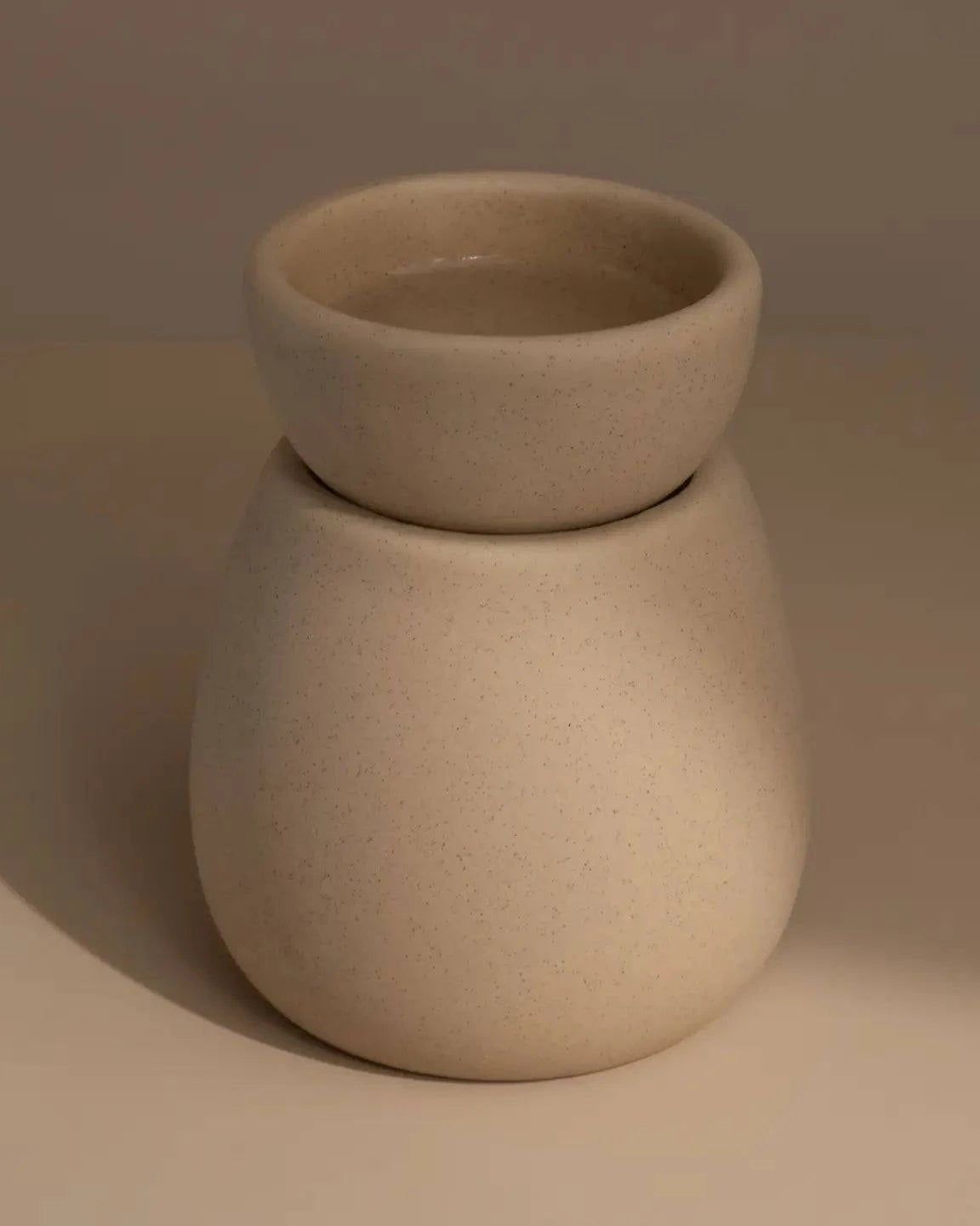 Back of Beige ceramic wax melt burner on a neutral table and background