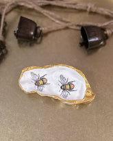 Handmade oyster shell trinket dish featuring two bumble bees, crafted using a meticulous decoupage technique with hand-painted gold edges, perfect for spring jewellery storage or home decor.