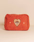 Rust-coloured corduroy makeup bag with a zip closure, fully lined, and five internal pockets. Features a pale orange heart with an eye design.