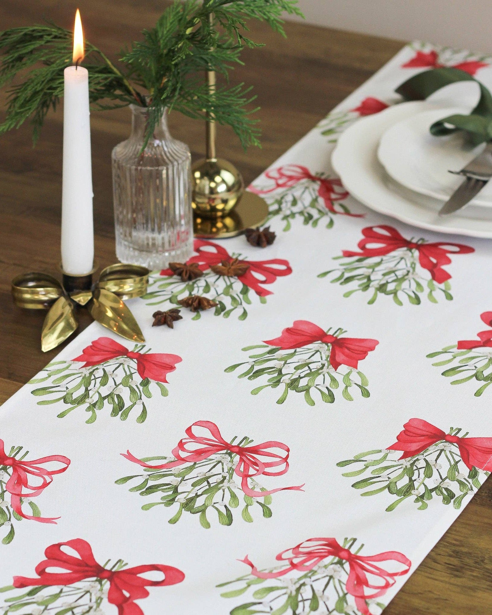 Cream table runner made from pure cotton, featuring red bows and mistletoe design.