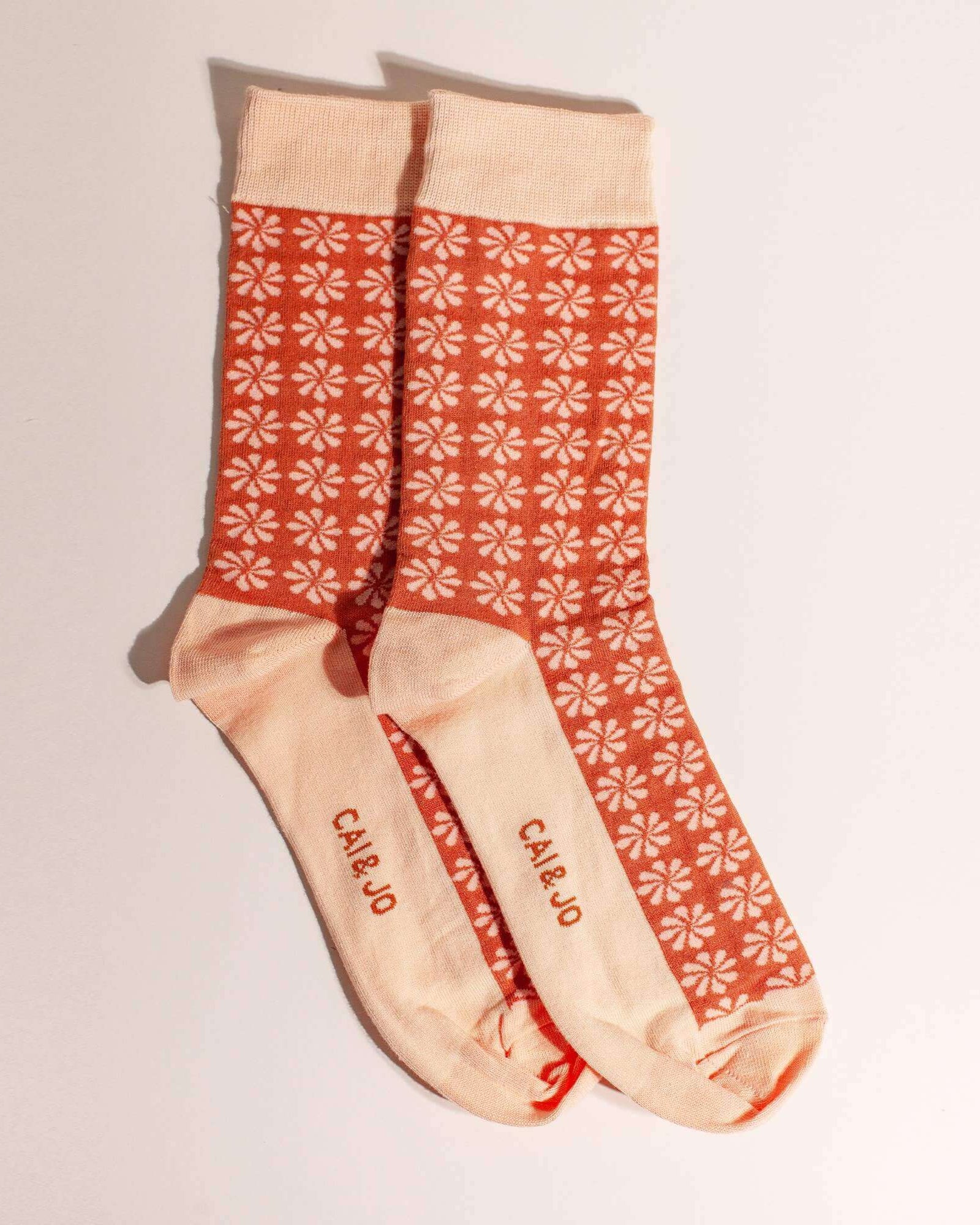 Orange socks with an all-over daisy flower pattern. Made from 75% cotton for a cosy fit, one size fits most.