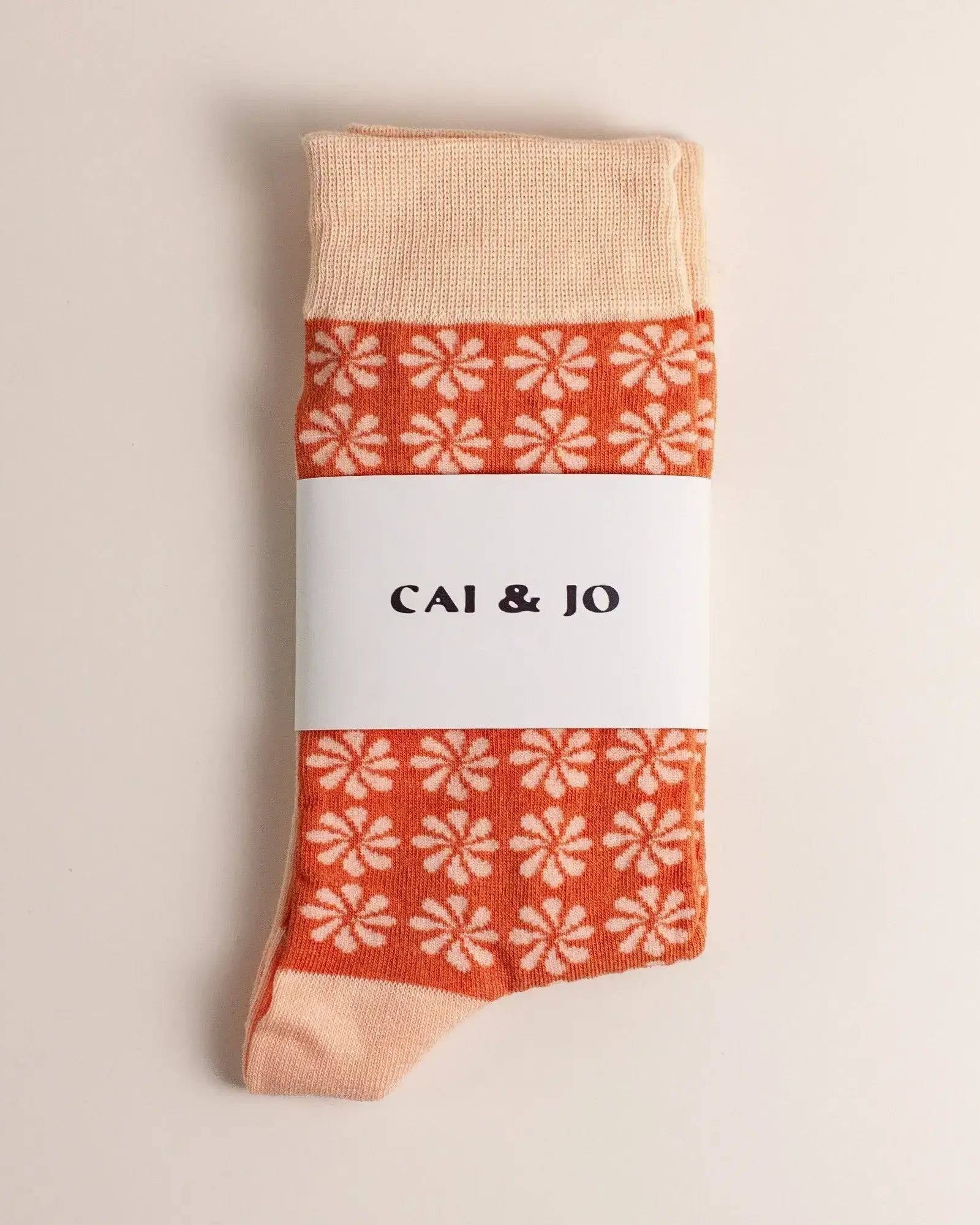 Orange socks with an all-over daisy flower pattern. Made from 75% cotton for a cosy fit, one size fits most.