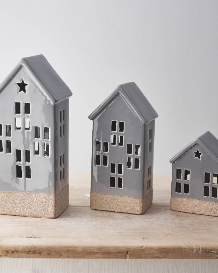 Small ceramic LED house with a white glaze finish and raw base. Hand-finished for a cozy look.