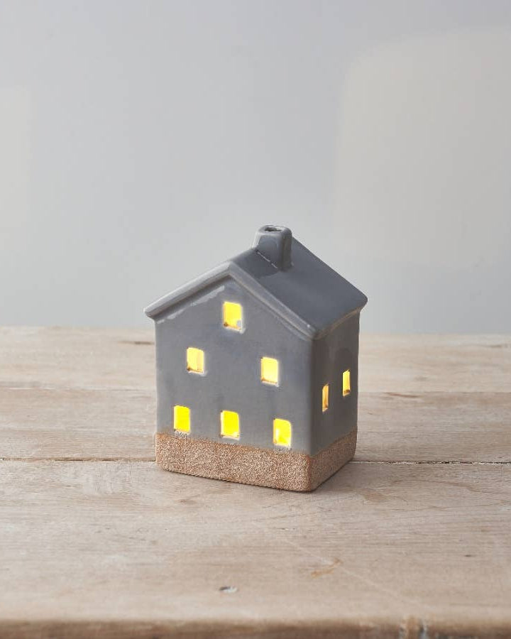 Small ceramic LED house with a white glaze finish and raw base. Hand-finished for a cosy look.
