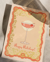 A6 handmade eco-conscious card in chic pink tones featuring a festive cocktail illustration with luxe gold foil. Includes a Kraft envelope and biodegradable cello wrap.
