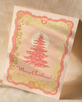 A6 handmade eco-conscious card with soft pink hues and luxe gold foil detailing, featuring a Christmas tree design. Includes a Kraft envelope and biodegradable cello wrap.
