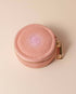 Dusty pink velvet polyester mini travel jewellery case with a zip closure and sun embroidery. Ideal for jewellery storage and travel.