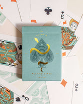 Premium-grade playing cards in sage green with a gold-foiled tuck box featuring an ace of spades design with a snake wrapped around it. Ideal for games and gifting.