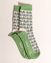 Green socks featuring an all-over palm tree design. Made from 75% cotton, one size fits most.