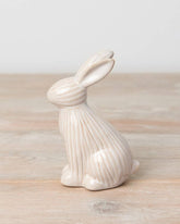 Sitting ceramic bunny with a ribbed reactive glaze finish in white/cream. A charming Easter or spring décor item.