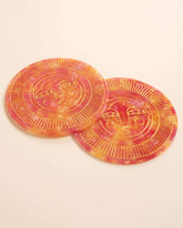Set of two round handmade coasters in passionfruit pink acetate with engraved, gold-filled Sol face detail. Suitable for indoor or outdoor use. Perfect for home décor or barware.