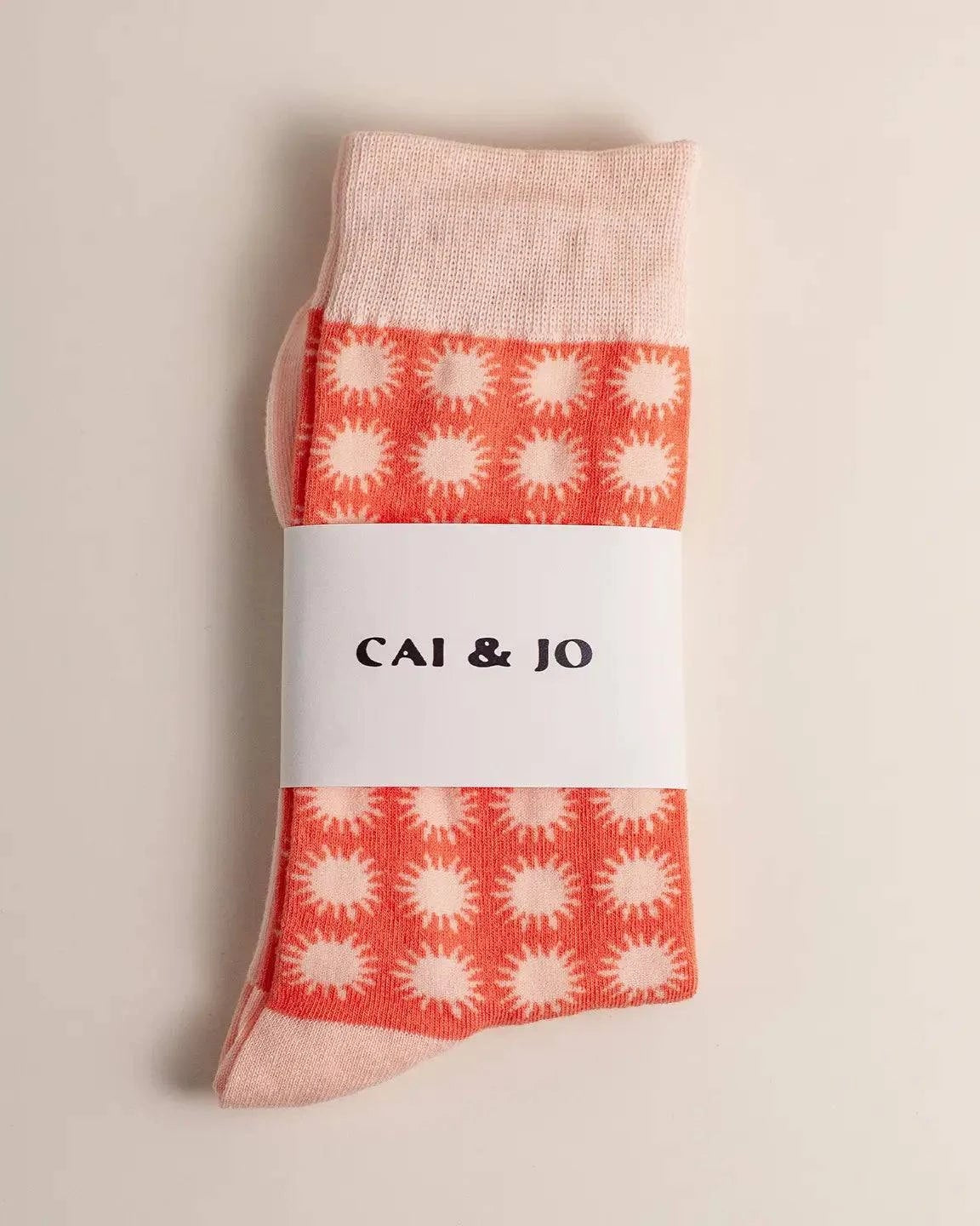 Orange socks featuring an all-over sunshine design. Made from 75% cotton for comfort, one size fits most. In packaging