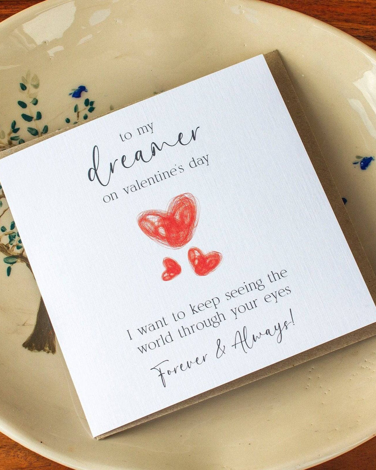 Handmade Valentine’s Day card featuring three red hearts and the text: "To my dreamer on Valentine’s Day, I want to see the world through your eyes forever and always."