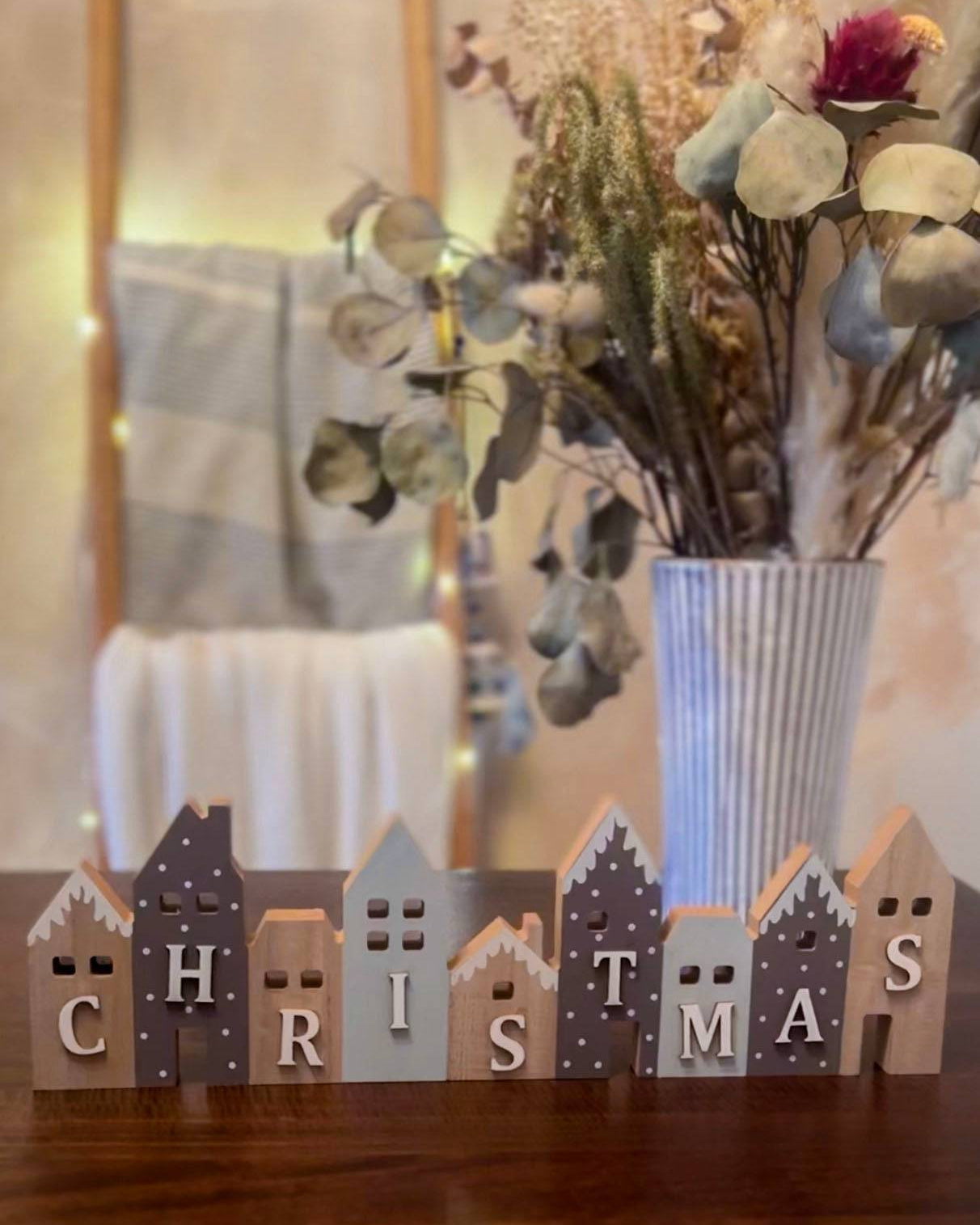Set of wooden Christmas houses adorned with blue and grey snow-effect designs. A charming festive décor piece.