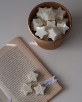Star-shaped objects in a bowl with an open book on a white surface