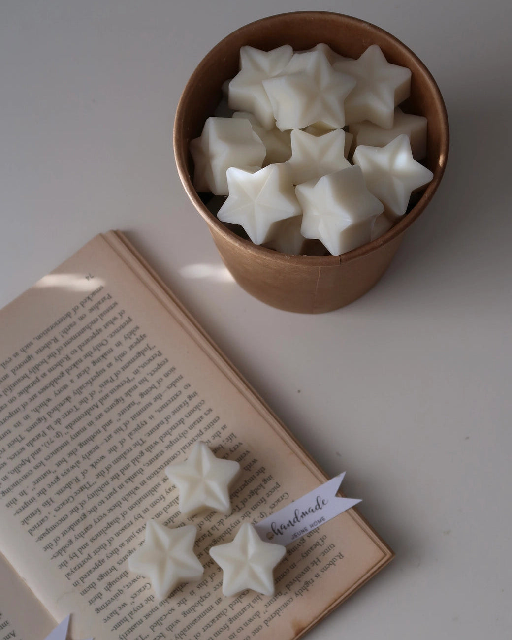 Star-shaped objects in a bowl with an open book on a white surface