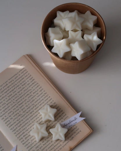 Star-shaped objects in a bowl with an open book on a white surface