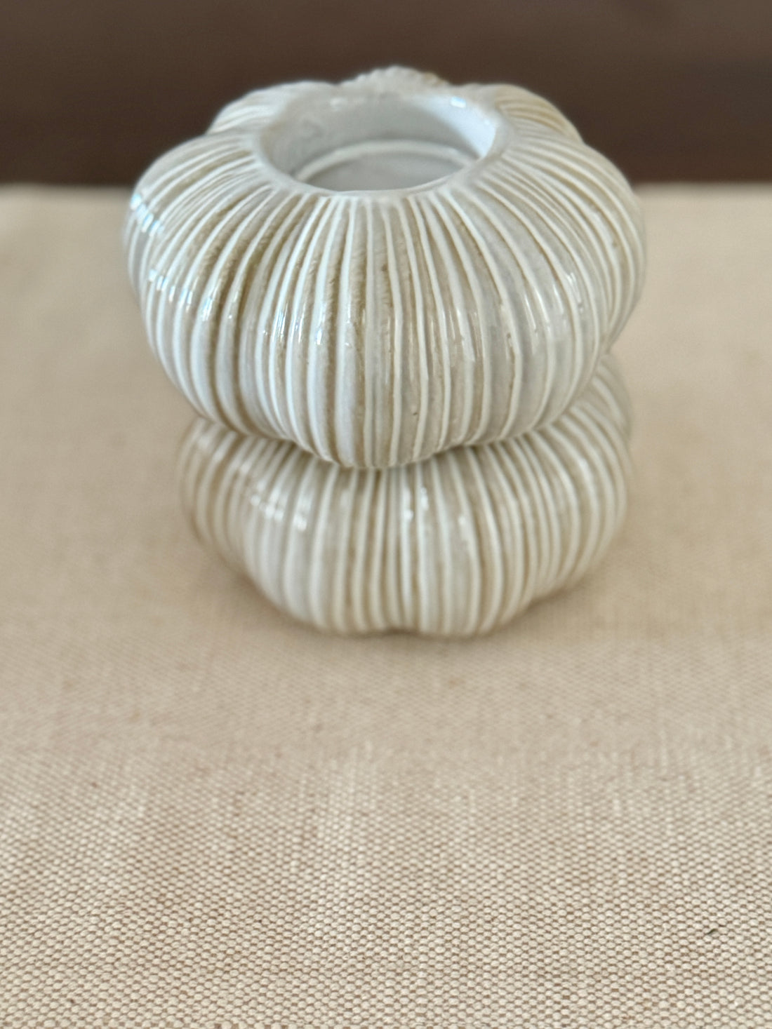 Stack of ribbed ceramic bowls on a beige surface