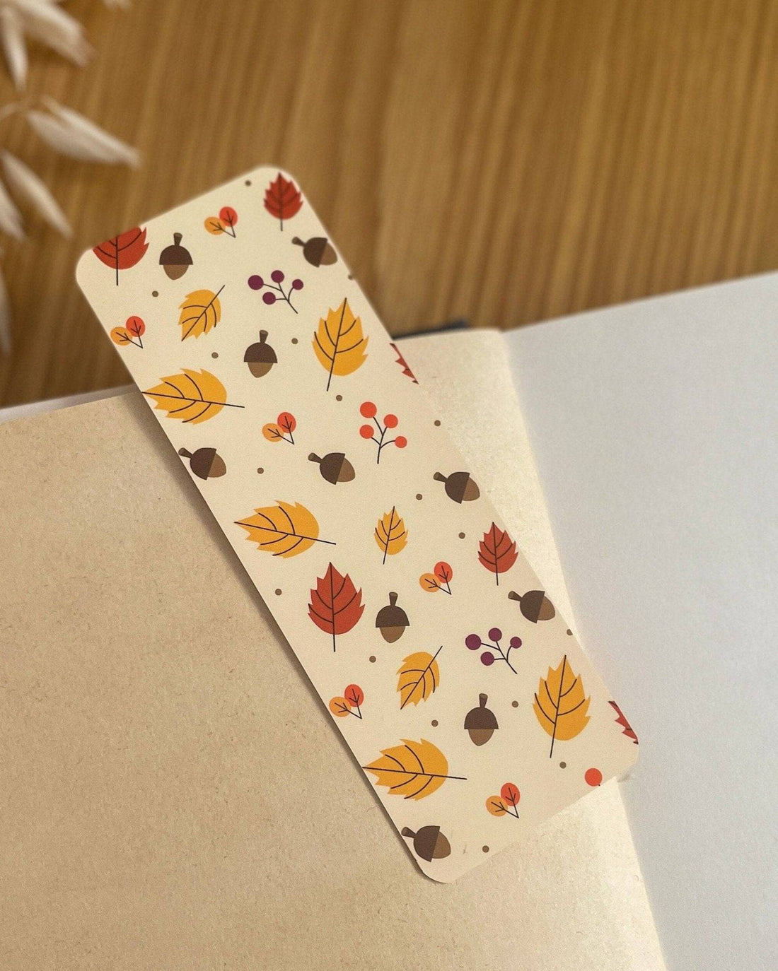 Autumn-themed waterproof bookmark featuring vibrant leaves in autumn colours, made from recycled tear-proof card stock with a velvet lamination. Perfect for book lovers.