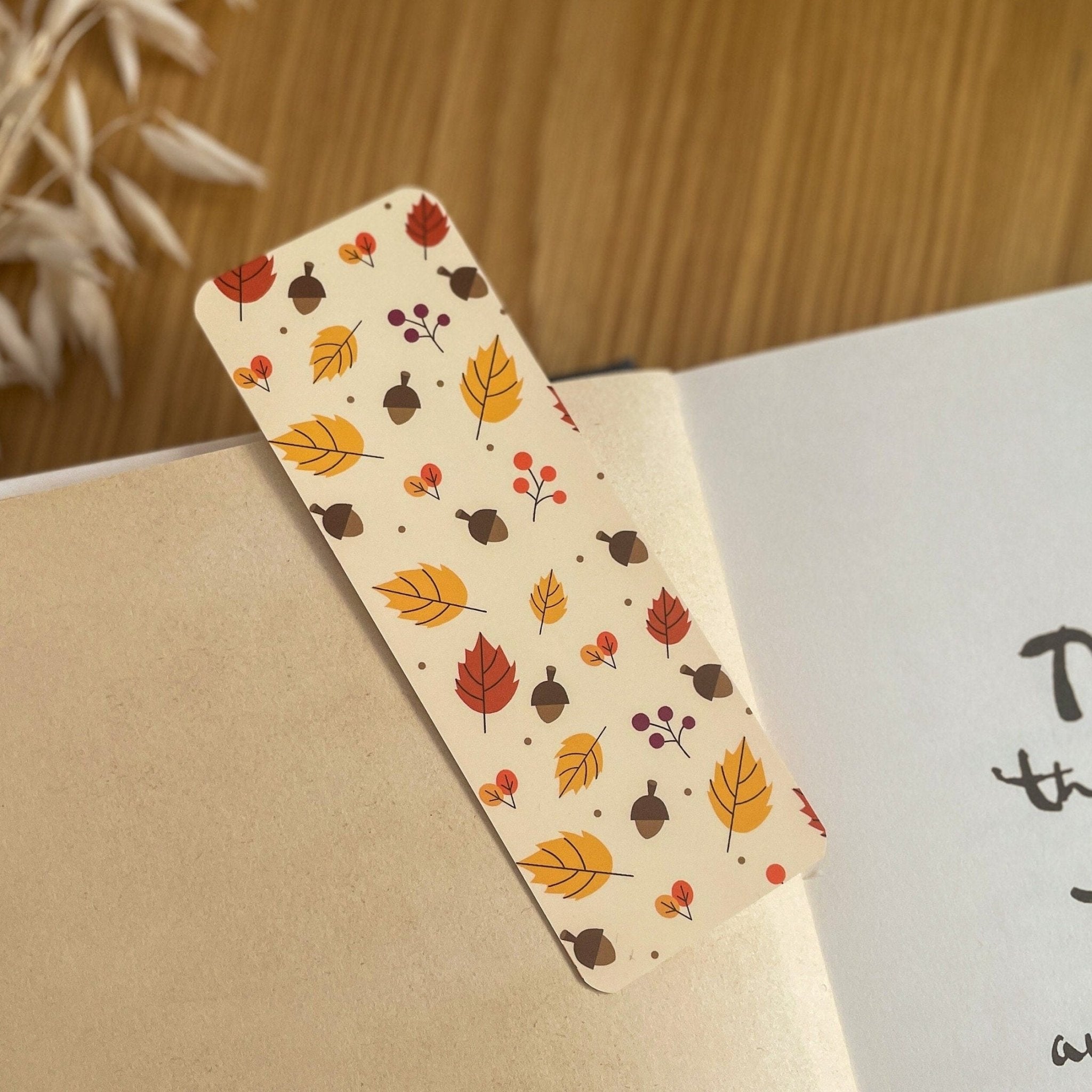 Autumn-themed waterproof bookmark featuring vibrant leaves in autumn colours, made from recycled tear-proof card stock with a velvet lamination. Perfect for book lovers.