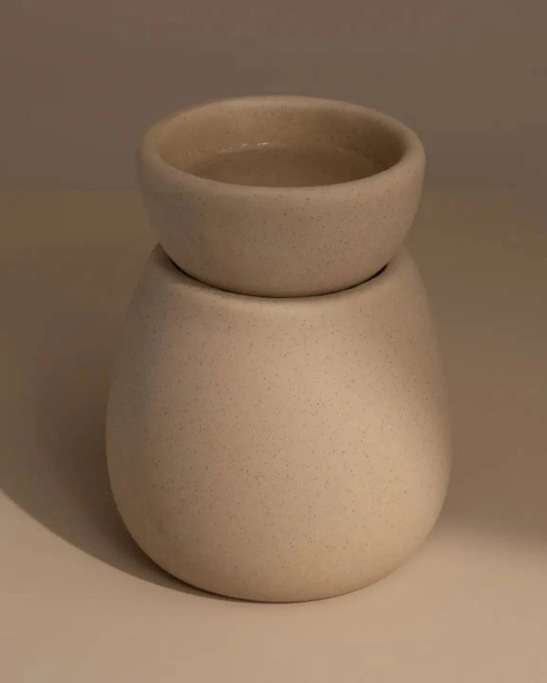 Back of Beige ceramic wax melt burner on a neutral table and background