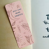 Boho-themed waterproof bookmark with "Just One More Chapter" text, featuring illustrations of moons, leaves, and abstract shapes in pink and brown tones. Made from recycled card with a velvet lamination.