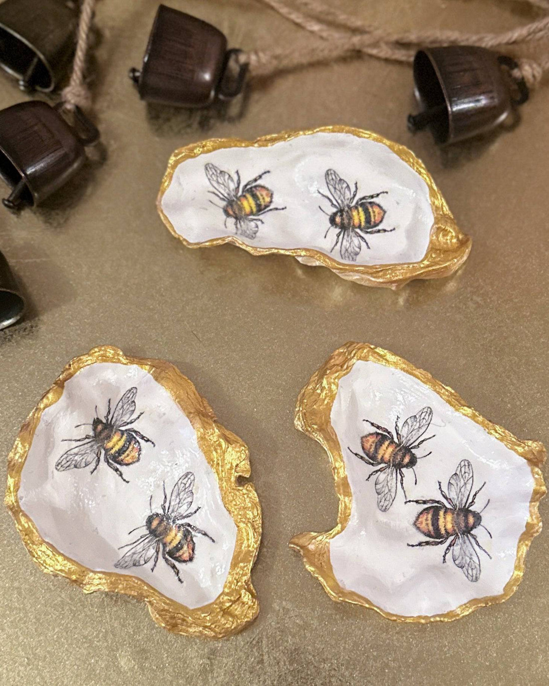Handmade oyster shell trinket dish featuring two bumble bees, crafted using a meticulous decoupage technique with hand-painted gold edges, perfect for spring jewellery storage or home decor.