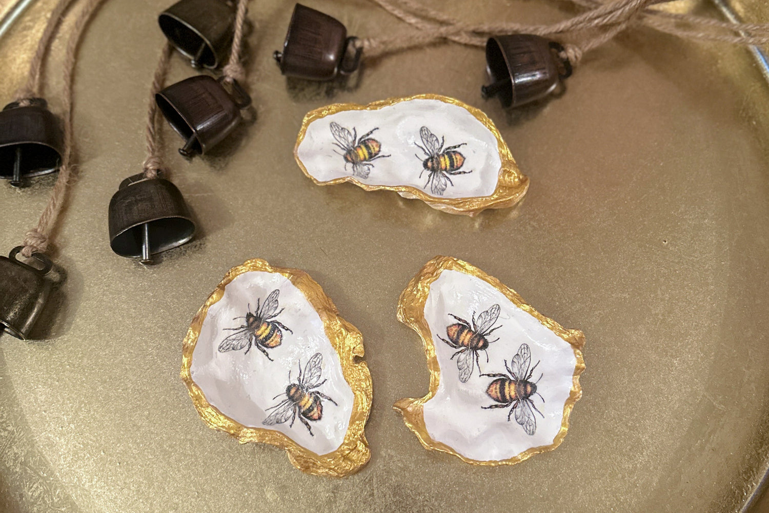 Handmade oyster shell trinket dish featuring two bumble bees, crafted using a meticulous decoupage technique with hand-painted gold edges, perfect for spring jewellery storage or home decor.