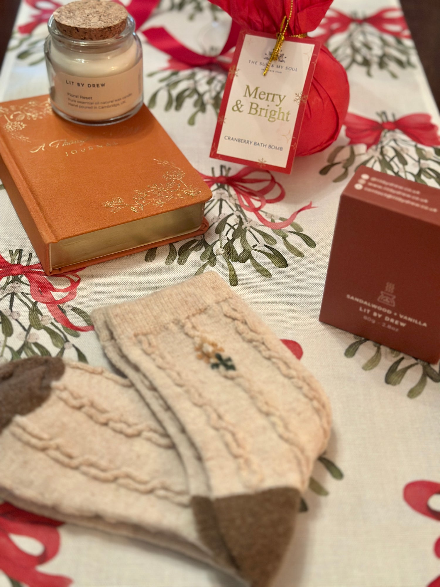 Gift box with a thought-a-day journal, cranberry bath bomb, floral socks, sandalwood melts, and aromatherapy candles. Perfect for a cosy night in.