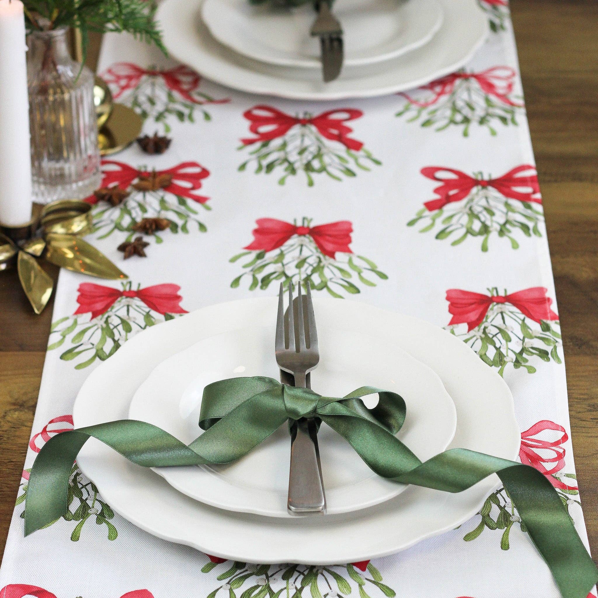 Cream table runner made from pure cotton, featuring red bows and mistletoe design.