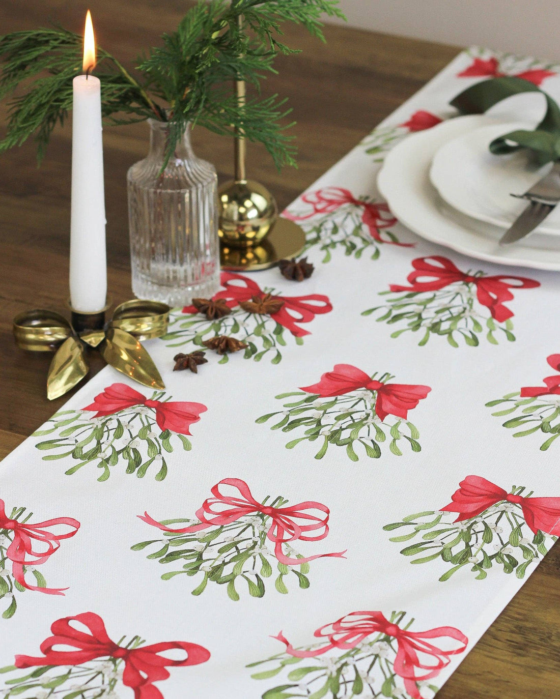 Cream table runner made from pure cotton, featuring red bows and mistletoe design.