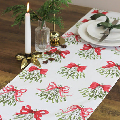 Cream table runner made from pure cotton, featuring red bows and mistletoe design.