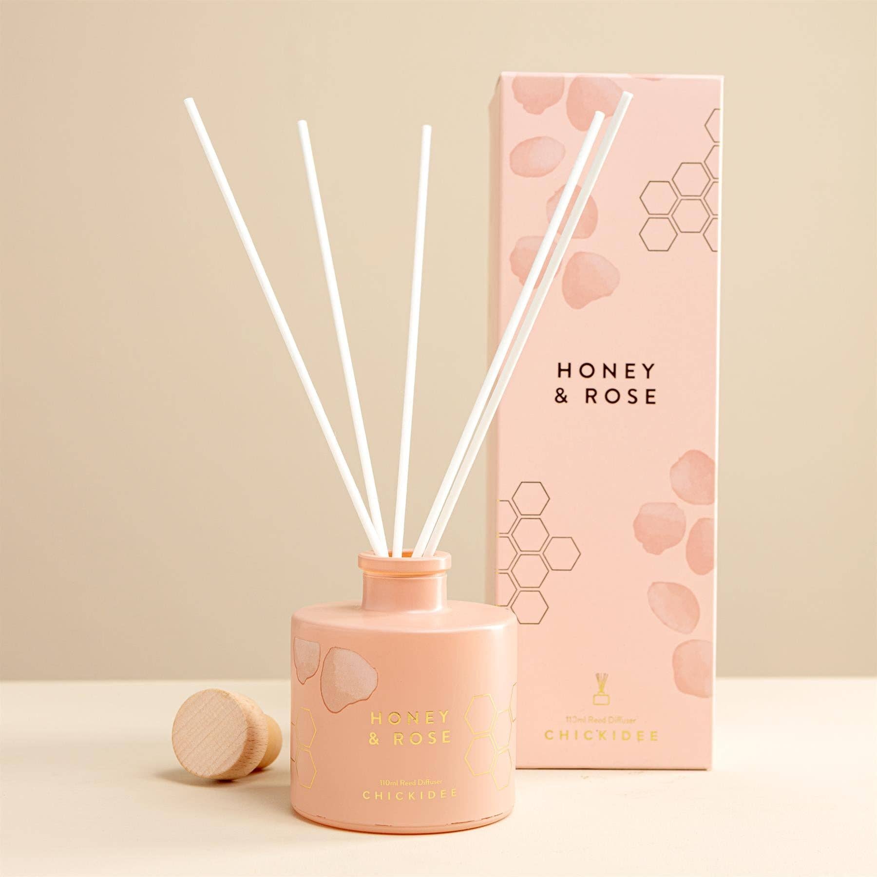 Handcrafted reed diffuser with natural botanicals and premium fragrance oils in a Honey & Rose scent.