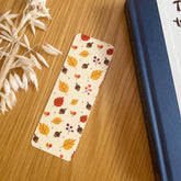 Autumn-themed waterproof bookmark featuring vibrant leaves in autumn colours, made from recycled tear-proof card stock with a velvet lamination. Perfect for book lovers.