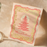 A6 handmade eco-conscious card with soft pink hues and luxe gold foil detailing, featuring a Christmas tree design. Includes a Kraft envelope and biodegradable cello wrap.