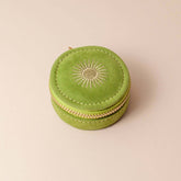 Avocado green velvet polyester mini travel jewellery case with a zip closure and a sun embroidery. Perfect for travel and jewellery storage.