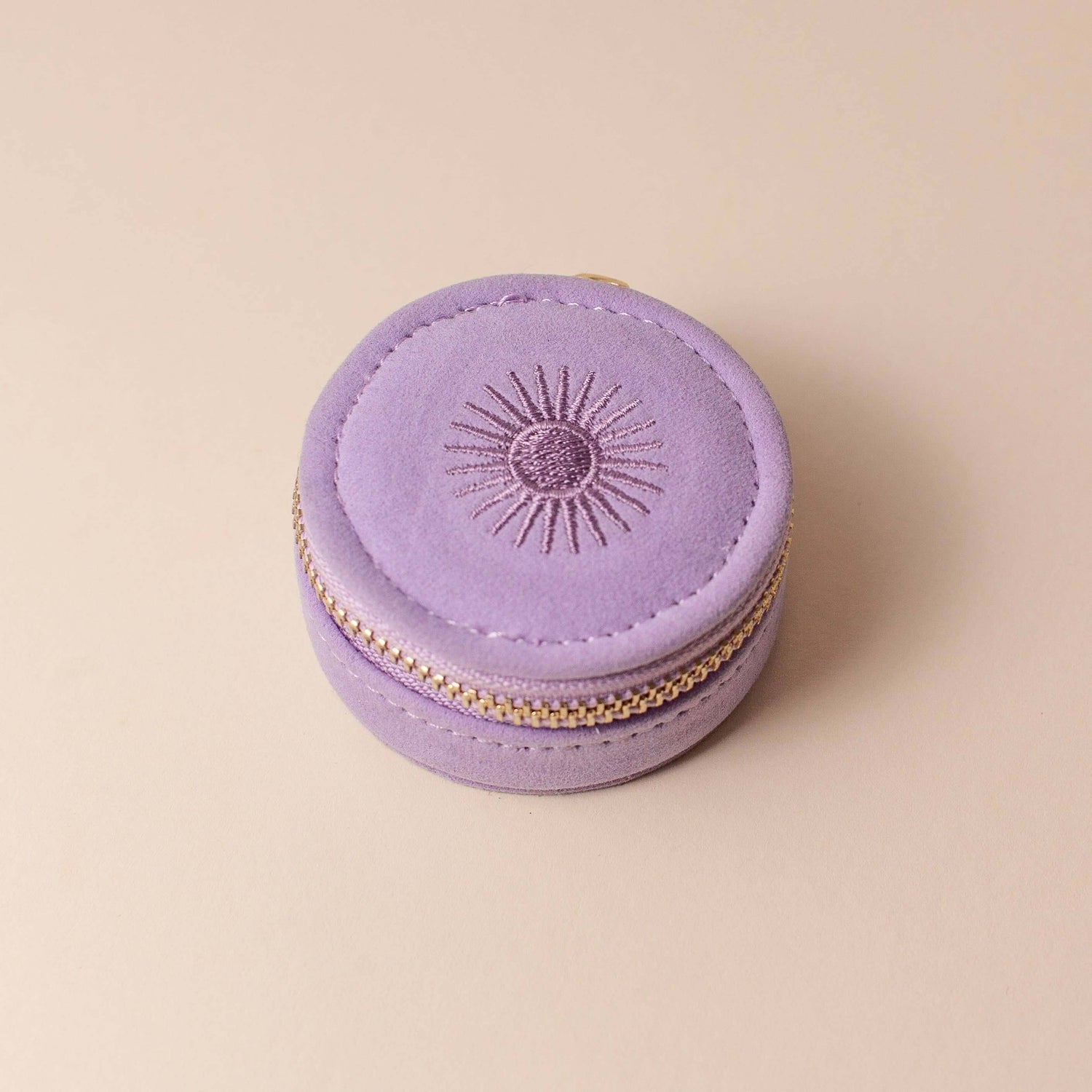 Lavender velvet polyester mini travel jewellery case with a zip closure and an embroidered sun design. Ideal for travel and jewellery storage.