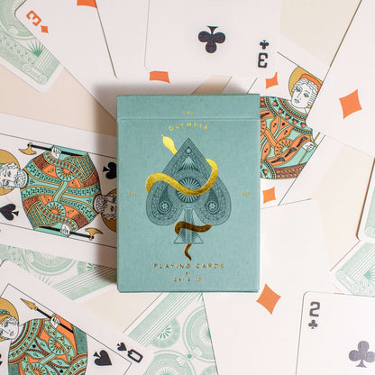 Premium-grade playing cards in sage green with a gold-foiled tuck box featuring an ace of spades design with a snake wrapped around it. Ideal for games and gifting.