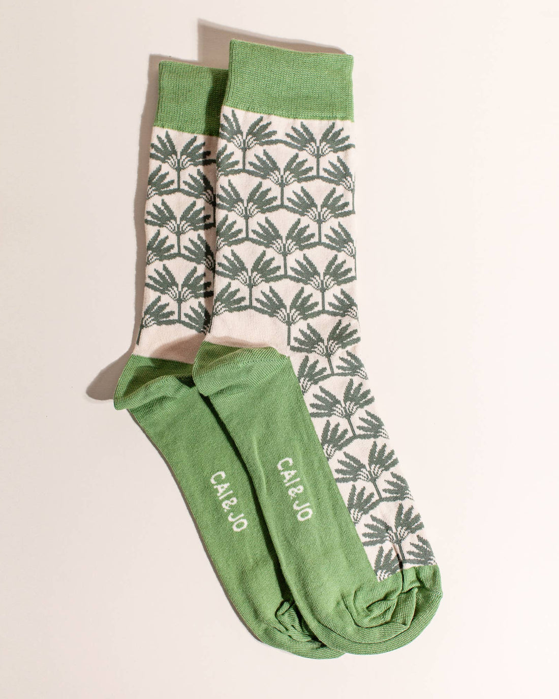 Green socks featuring an all-over palm tree design. Made from 75% cotton, one size fits most.