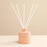 Handcrafted reed diffuser with natural botanicals and premium fragrance oils in a Honey & Rose scent.