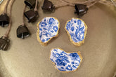 Set of three handmade oyster shell trinket dishes with blue and white floral designs, featuring a decoupage technique and hand-painted gold edges, ideal for home decor or jewellery storage.