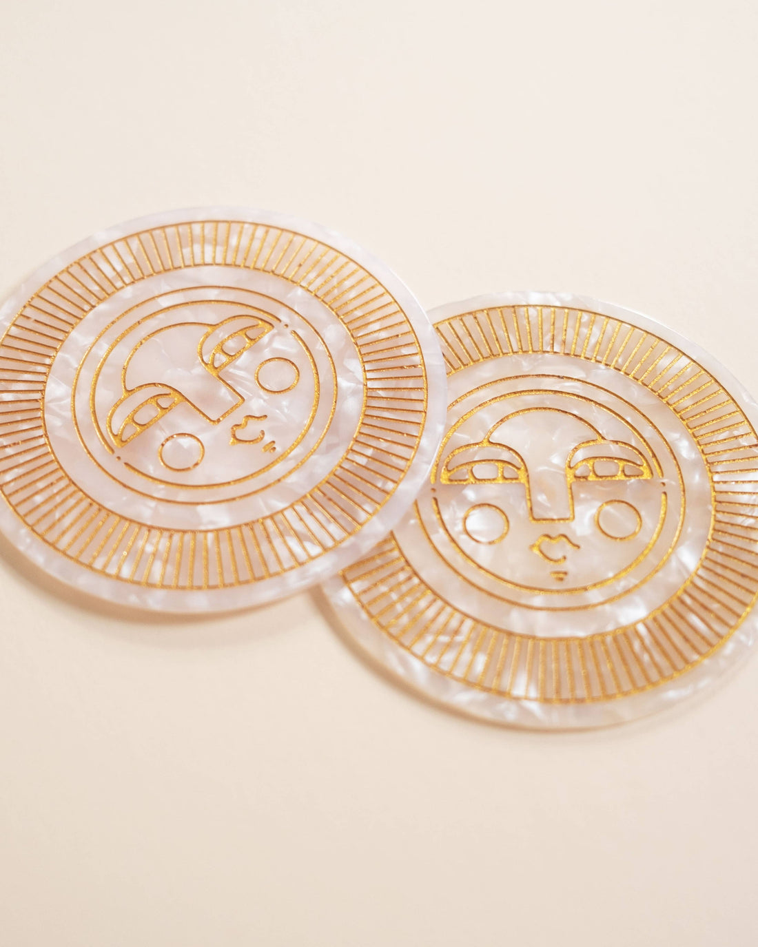 Set of two round pearl acetate coasters with engraved, gold-filled Sol face detail. Handmade for both indoor and outdoor use. Ideal for home décor or barware.