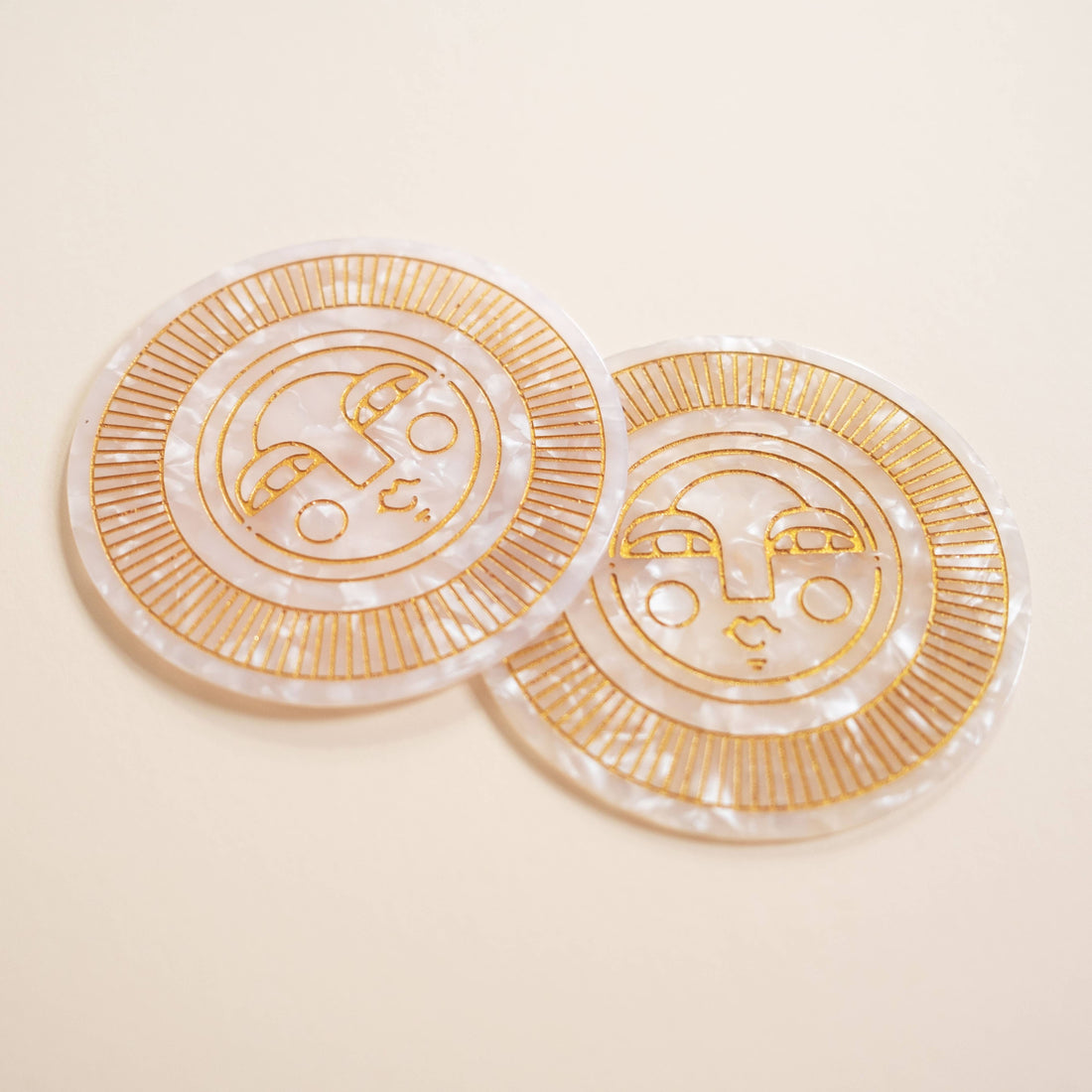 Set of two round pearl acetate coasters with engraved, gold-filled Sol face detail. Handmade for both indoor and outdoor use. Ideal for home décor or barware.